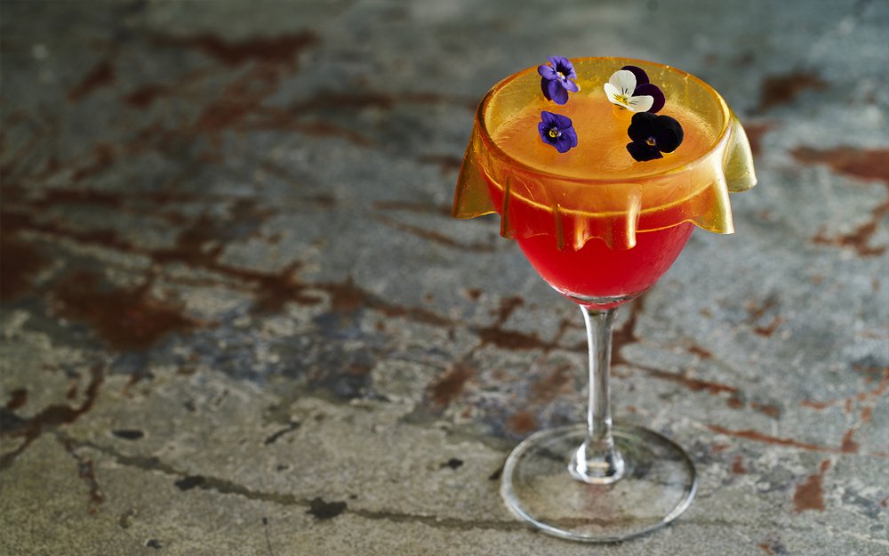 A colorful cocktail with violet flowers