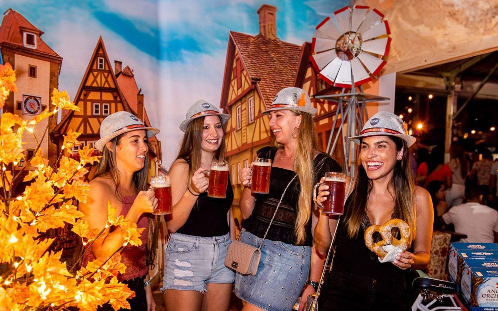 Mulheres comemorando a Oktoberfest com cerveja e pretzels