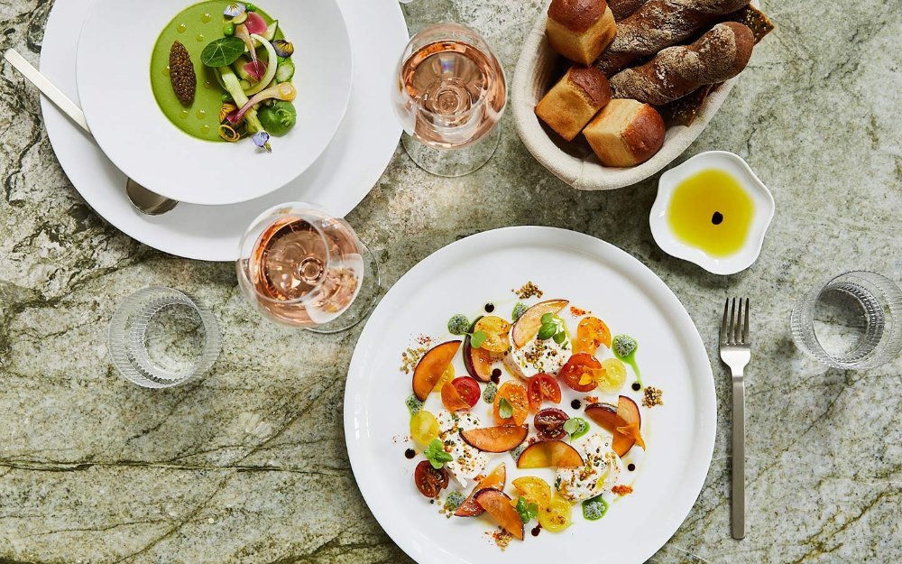 A table spread at Le Jardinier, showcasing vibrant colors and seasonal dishes, highlighting the freshness and artistry of the cuisine