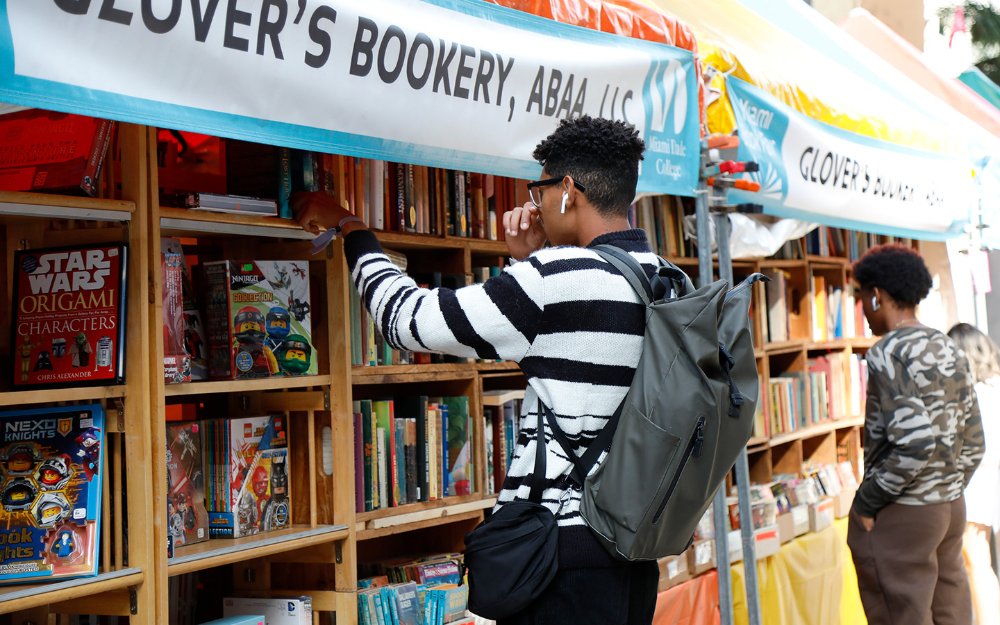 Meninos folheando estantes de livros na Feira de Rua