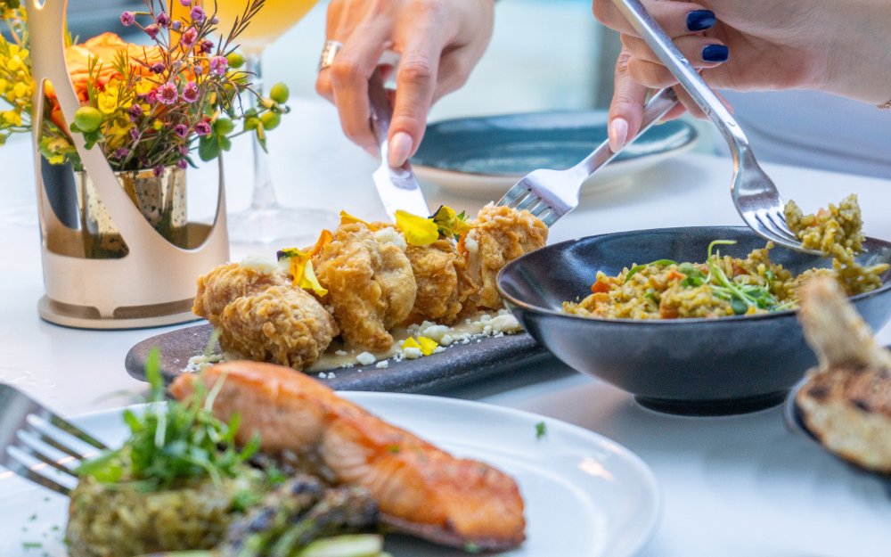 Varietà di piatti, tra cui un piatto di salmone splendidamente impiattato, circondato da altri cibi colorati e appetitosi