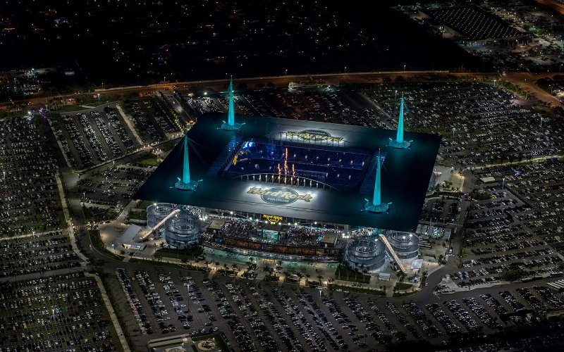 As torres icônicas são difíceis de perder nesta vista aérea de Hard Rock Stadium à noite
