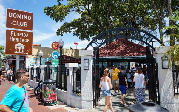 People walking through the entrance of Maximo Gomez Park known as Domino Park