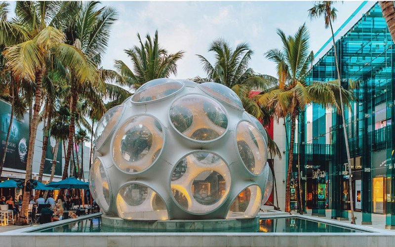 Fly's Eye Dome nel Design District di Miami, una sorprendente struttura geometrica con aperture circolari, che si staglia su uno sfondo luminoso e moderno